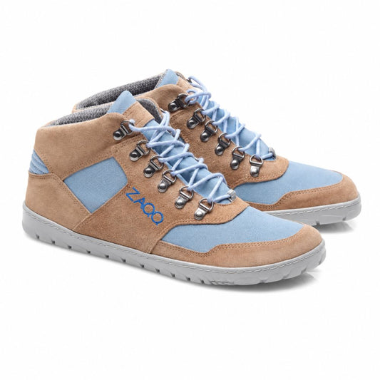 Die ZAQQ HIQE Mid Sky Waterproof Sneaker sind Mid-Top-Sneaker mit Einsätzen aus braunem Wildleder und blauem Stoff. Sie haben graue Schnürsenkel, silberne Ösen und eine hellgraue Sohle. Auf der Seite ist der Markenname ZAQQ aufgedruckt.