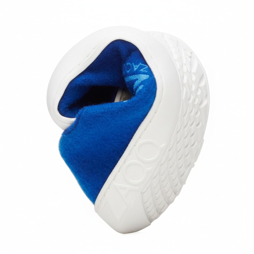 Der beliebte LIQE Azur Barfußschuh von ZAQQ mit schmutziger, abgenutzter Sohle ist zu einem Herz gebogen. Das leuchtend blaue Innenfutter aus Merinowolle bildet einen schönen Kontrast zur Außenseite, auf der stolz das Wort ZOZO prangt.