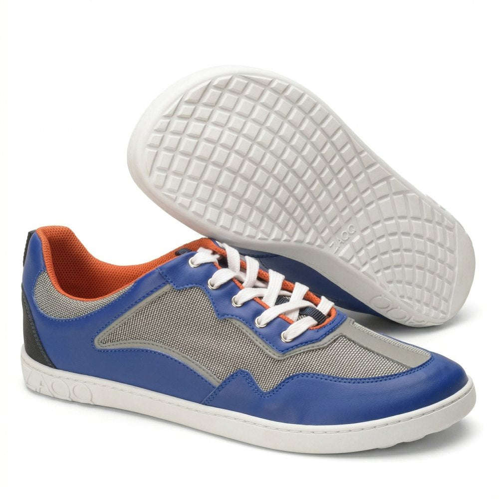 Die QOPA Blue Sneaker von ZAQQ zeichnen sich durch ein atmungsaktives blau-graues Mesh-Design, ein orangefarbenes Futter und weiße Schnürsenkel aus. Ein Schuh wird aufrecht und der andere auf der Seite präsentiert und hebt eine strukturierte Sohle hervor.