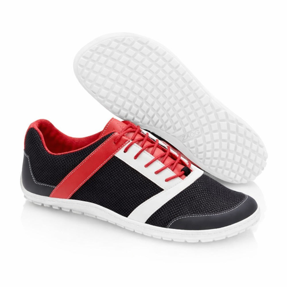 Entdecken Sie den ZARQA Black von ZAQQ: Sportschuhe mit einem eleganten schwarzen Design und strukturierten Sohlen, die sich ideal für jedes Gelände eignen. Dieser Outdoorschuh zeichnet sich durch kräftige rote und weiße Akzente, rote Schnürsenkel und ein kuscheliges rotes Innenfutter aus. Ein Schuh steht aufrecht und unterstreicht seinen anspruchsvollen Stil, während der andere seine sorgfältig gefertigte Sohle zur Schau stellt.